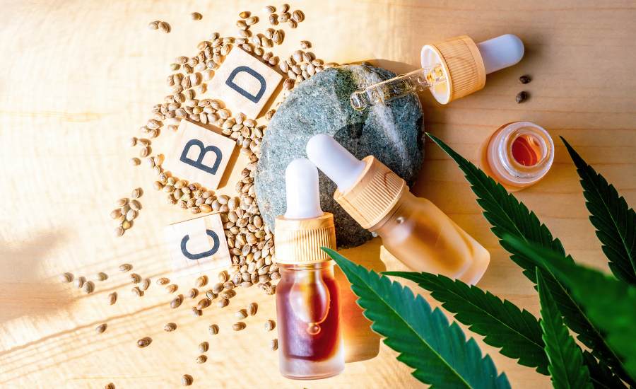 Mise en scène bien-être avec fleurs séchées, feuille de chanvre et fiole d’huile de CBD, illustrant une solution naturelle pour se détendre et favoriser la récupération après un burn-out.
